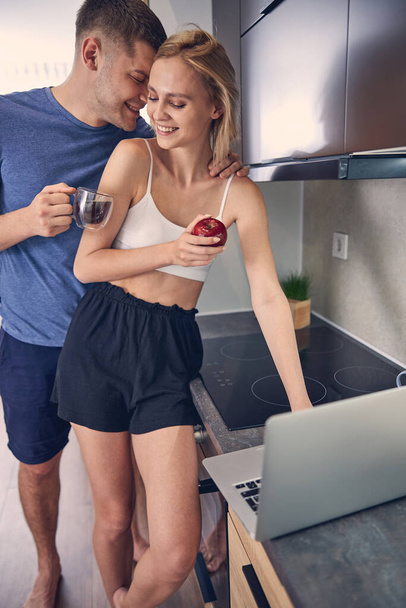 Young smiling couple spending time near computer - Photo, Image