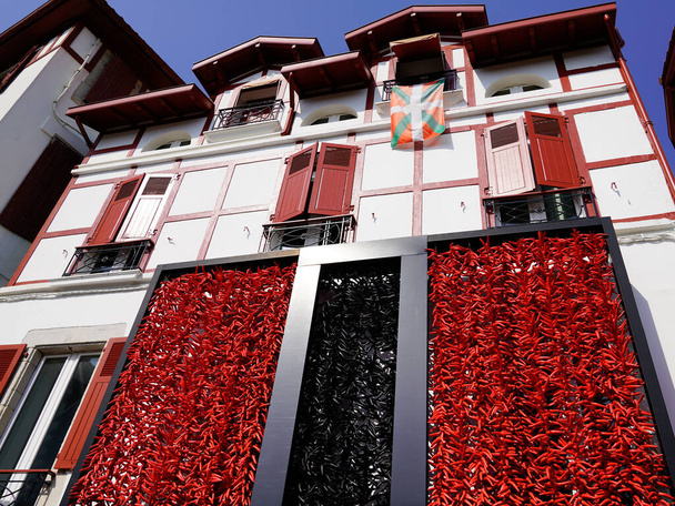 Červené a černé papriky visí sušení na fasádě typického baskického domu - Fotografie, Obrázek