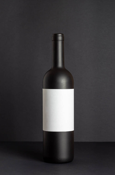 Black wine bottle on a black background. Mock-up. Copy space - Fotó, kép