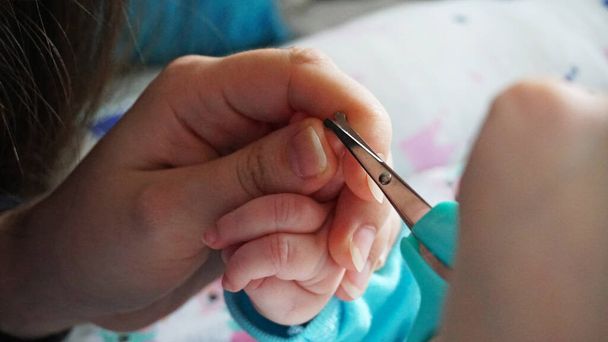 Un recién nacido uñas de los niños se cortan con tijeras. - Foto, imagen