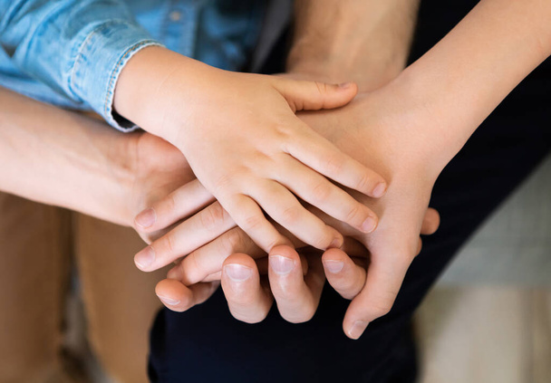 Egyesült szülők és gyerekek egymás kezét fogva, közelkép, felső nézet - Fotó, kép