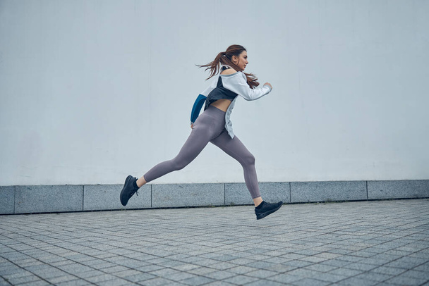 Fit young Caucasian lady moving in midair - Foto, afbeelding