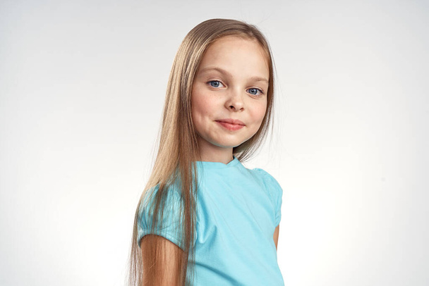 Sevimli kız mavi elbiseler kırpılmış görünüm ışık arka plan duyguları çocukluk eğlencesi - Fotoğraf, Görsel