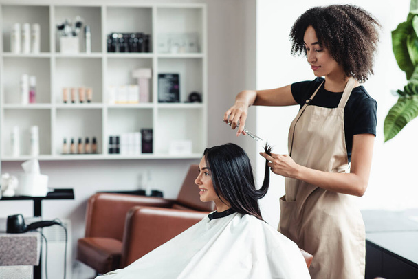 Jeune femme appréciant la coupe de cheveux au salon de beauté, espace vide - Photo, image