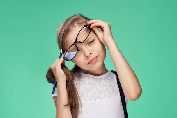 scolaretta indossa occhiali con zaino di apprendimento educazione sfondo verde - Foto, immagini