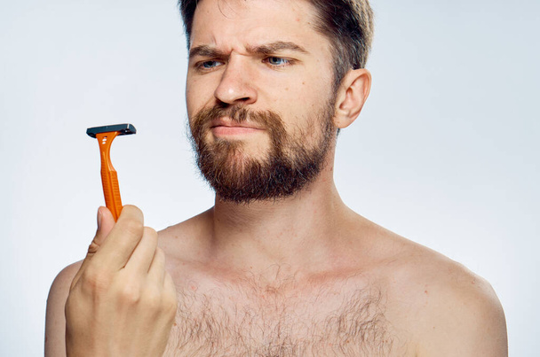 Чоловік з бритвою в руці Борода догляд за шкірою обличчя ранковий спосіб життя чиста шкіра
 - Фото, зображення