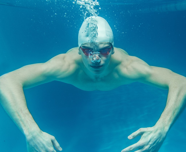 スイム キャップとスイミング プールの水の下でグーグルの男 - 写真・画像