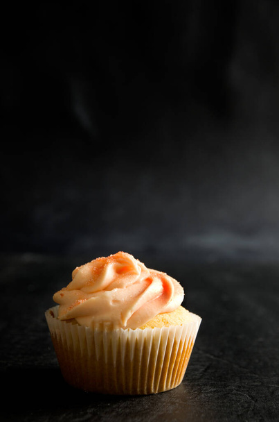 Delicioso Muffin con hielo y azúcar sobre fondo oscuro Vertical - Foto, imagen