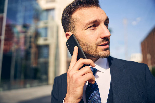 Jeune homme caucasien parler à l'extérieur sur téléphone mobile - Photo, image