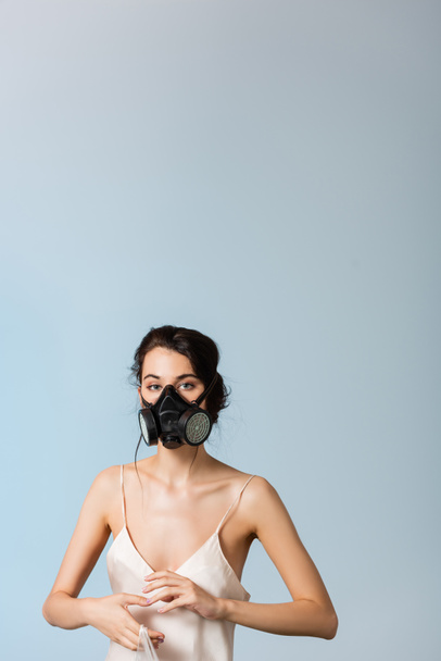 brunette woman in gas mask holding plastic bag isolated on grey, ecology concept  - Foto, imagen