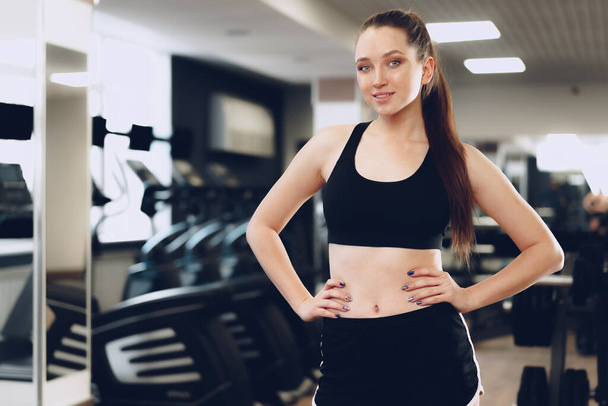 Portrait of a young sporty caucasian woman training in a fitness club - Fotó, kép