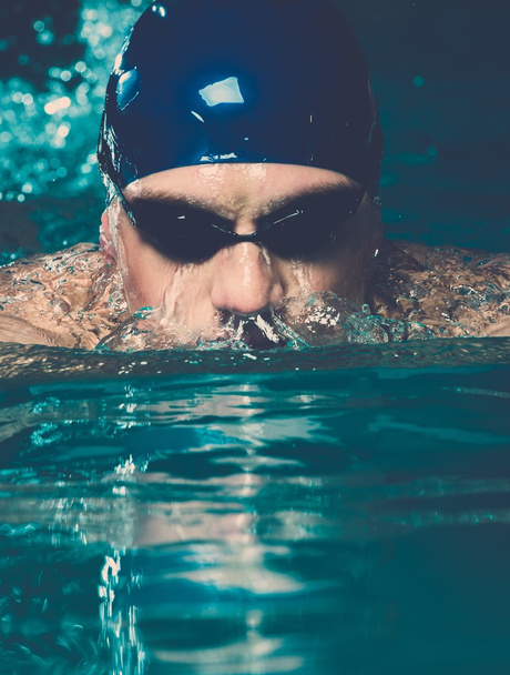 μυϊκή νεαρός άνδρας στο μπλε καπάκι στην πισίνα - Φωτογραφία, εικόνα