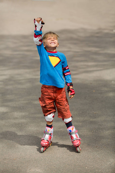 Boy rollerblading with family outdoors in the street - Foto, afbeelding