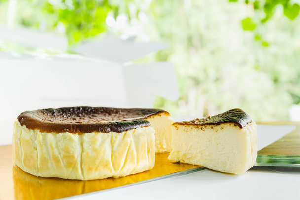 Fetta di torta di formaggio bruciata basca fatta in casa su tavolo bianco - Foto, immagini