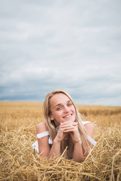 Portrait of bohemian girl with white art posing over wheat field - Foto, Imagen