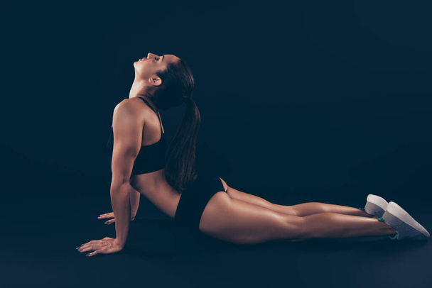 Profile side view of her she nice attractive sportive focused concentrated peaceful calm lady bending over on floor perfect abs total abdominal pecs isolated over black background - Valokuva, kuva