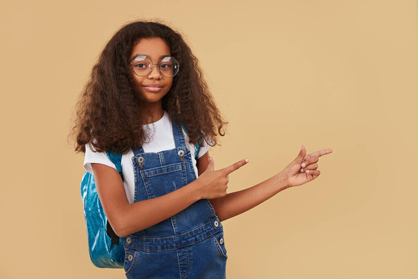 African American schoolgirl pointing away - Foto, imagen