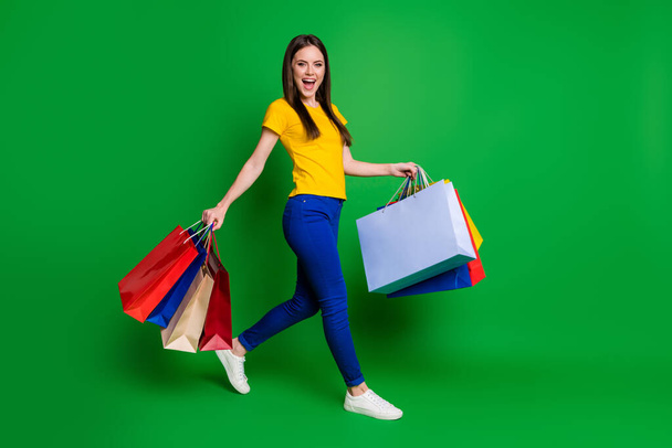 Full length body size view portrait of nice attractive pretty glad cheerful girl going visiting bargain carrying new things weekend holiday isolated bright vivid shine vibrant green color background - Fotografie, Obrázek