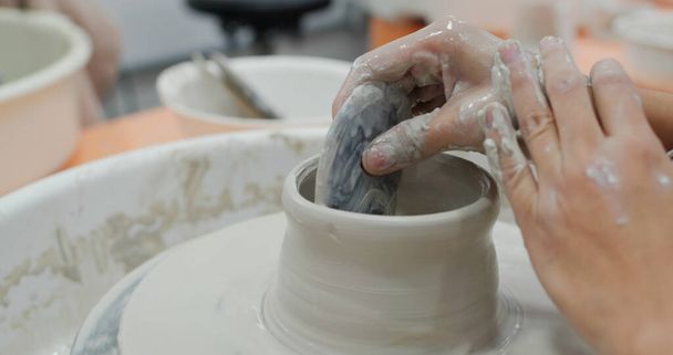 Student work on making ceramic pot on turning pottery wheel - Photo, Image