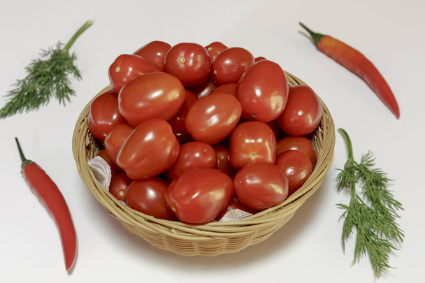 Tomates cherry en una canasta sobre fondo blanco, Listo para comer, Comida vegana. - Foto, imagen
