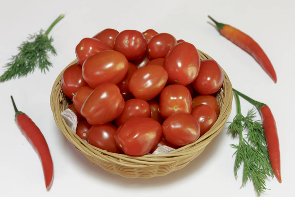 Tomates cherry en una canasta sobre fondo blanco, Listo para comer, Comida vegana. - Foto, imagen