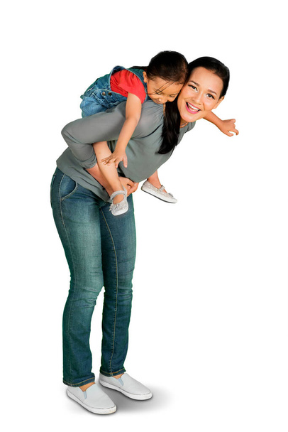 Beautiful mother piggybacking her daughter while playing together in the studio. Shot in 4k resolution - Photo, Image