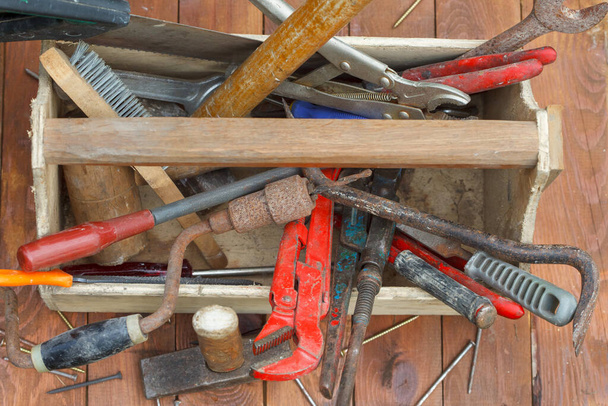 Caja de herramientas de madera con diferentes herramientas de trabajo vintage. Caja de herramientas de carpintero viejo con herramientas en la mesa de madera, vista superior. - Foto, Imagen