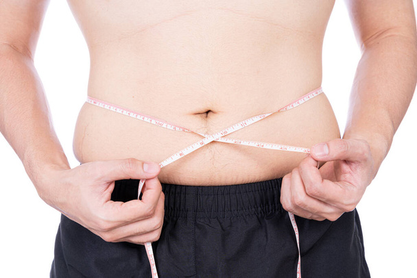 Hombre regordete midiendo su cintura con cinta métrica blanca aislada sobre fondo blanco. Estilo de vida de la dieta, pérdida de peso, músculo del estómago, concepto saludable. - Foto, imagen