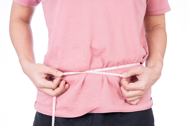 Homem gordinho medindo sua cintura com fita métrica branca isolada em fundo branco. Estilo de vida da dieta, perda de peso, músculo do estômago, conceito saudável. - Foto, Imagem