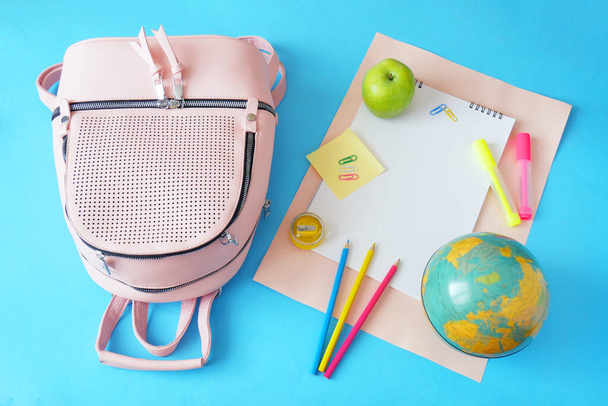 Volver a la escuela, libros de pila, lápices, manzana, globo y manzana sobre el fondo de pizarra - Foto, imagen