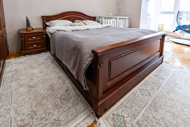 古典的な木製の茶色の寝室の家具。柔らかい快適なベッド. - 写真・画像