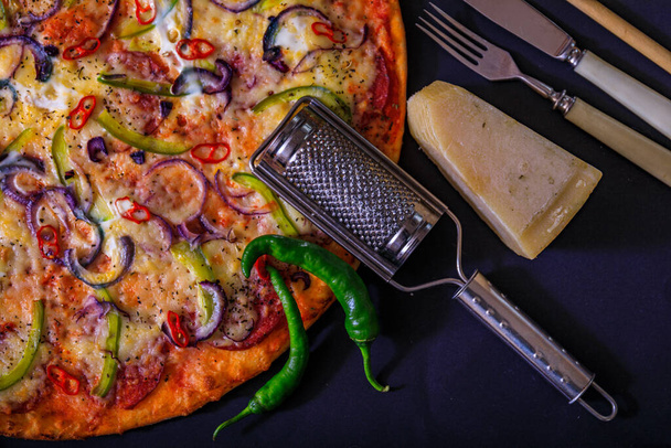 Pizza Margherita σε μαύρο φόντο πέτρα, πάνω άποψη. Πίτσα Μαργαρίτα με ντομάτες, βασιλικό και μοτσαρέλα. - Φωτογραφία, εικόνα