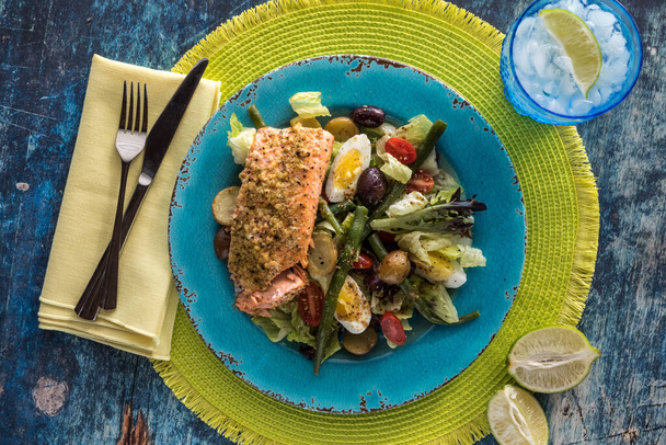 Nicoise salad with salmon on a bright blue plate ready for eating. - Photo, Image