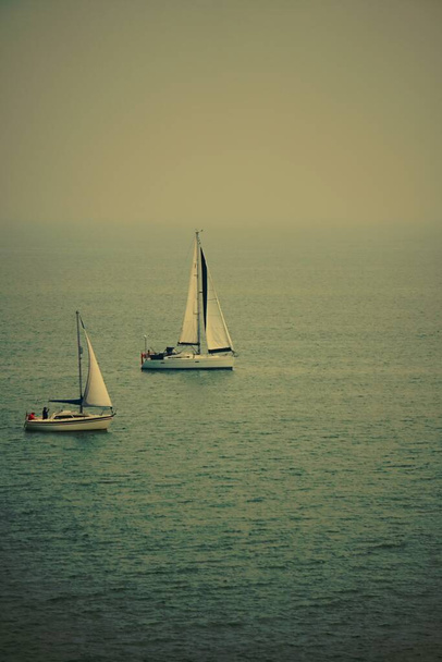Misty uitzicht op twee boten op zee  - Foto, afbeelding