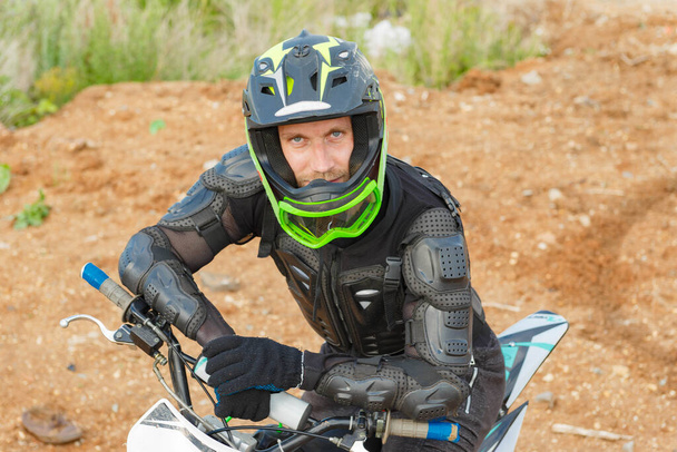 A man in motorcycle equipment sits on an enduro motorcycle. Motocross rider in action. Motocross sport. Extreme off-road race. Hard enduro motorbike. - Foto, immagini