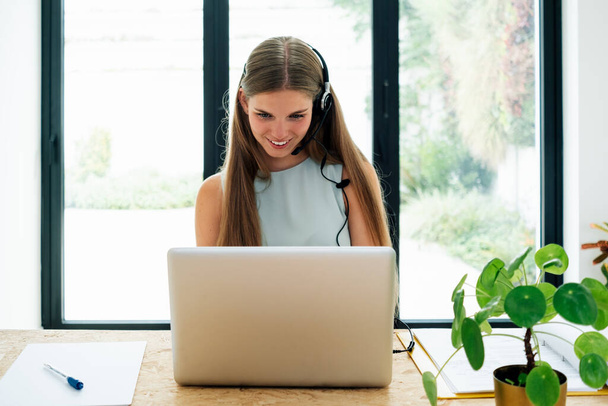 Young business woman working at home with laptop and papers on desk, female student talking on conference call, one people watching webinar by webcam, online learning, teaching concept - Photo, Image