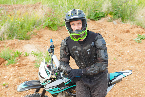 A man in motorcycle equipment sits on an enduro motorcycle. Motocross sport. Extreme off-road race. - Foto, immagini