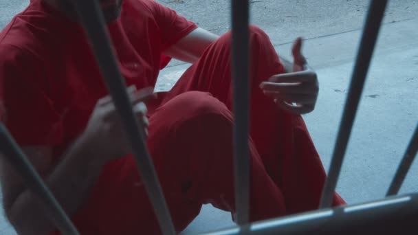Häftling redet hinter Gittern und gestikuliert im Gefängnis oder Gefängnis. - Filmmaterial, Video