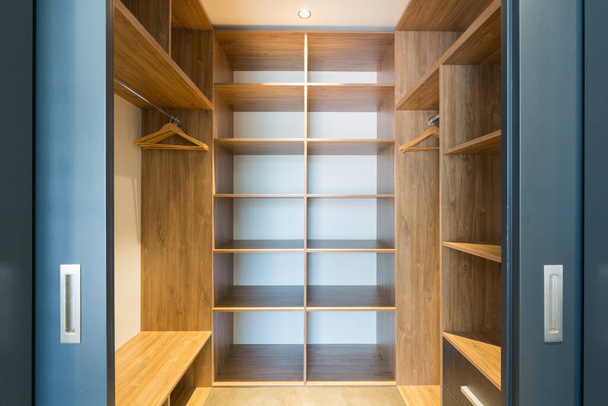 Empty storage room wardrobe cloakroom interior organization with shelving, hanging rails and shoe racks - Foto, Bild