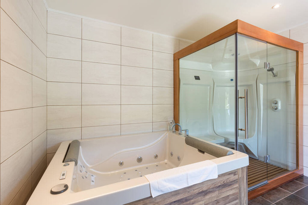 interior of luxury hotel bathroom with hydromassage bathtub and shower cabin - Foto, Imagen
