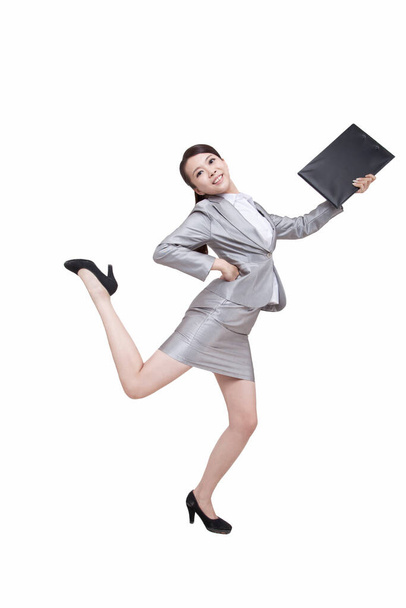	Portrait of young businesswoman jumping,holding folder	 - Photo, Image