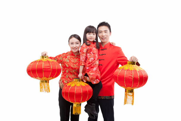 Портрет семьи, дочь с красным фонарем, отец с дочерью в руках, родители с красными фонарями, в костюмах танга - Фото, изображение