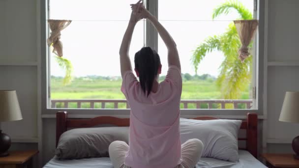 jovem mulher asiática acorda e se estende em seu quarto na atmosfera rústica fora. - Filmagem, Vídeo