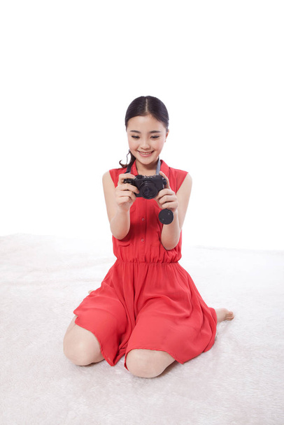 	Young woman looking at images on the camera 	 - 写真・画像
