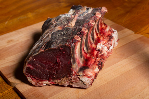 Raw dry aged ribs on wooden board - Photo, image