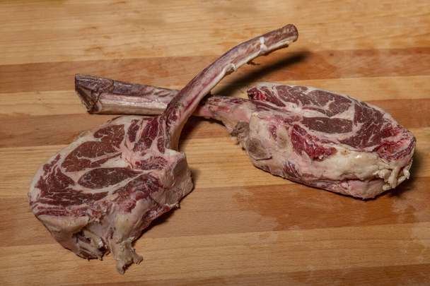 Raw rib eye steak ribs on wooden board - Foto, Imagem