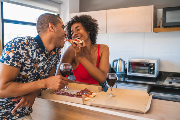 Retrato de feliz pareja latina joven disfrutando y cenando en casa nueva. Estilo de vida y concepto de relación. - Foto, imagen