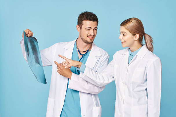 Mladí lékaři s rentgenem izolovaným na modré  - Fotografie, Obrázek