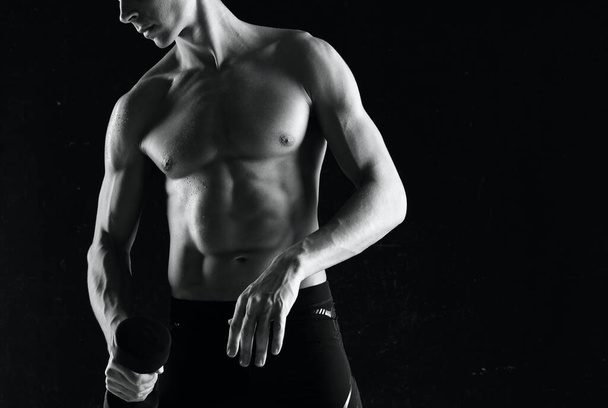 Young muscular fit  man  in studio lifting dumbbell  - Φωτογραφία, εικόνα