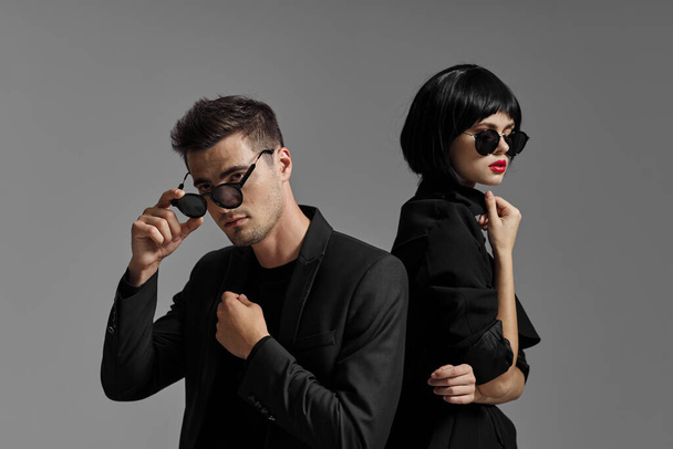 young beautiful stylish couple  in sunglasses  posing  in studio, isolated - 写真・画像